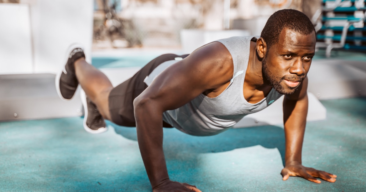 Poudre de créatine monohydrate dans un shaker avec des haltères en arrière-plan